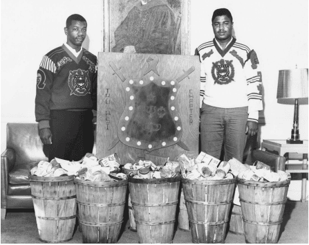 Omega Psi Phi Members with Baskets of Canned Food for Charity, 1964